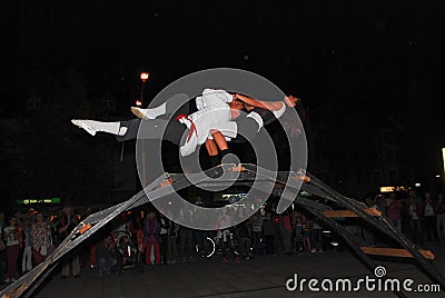 Two performance artists balance on top of a bridge Editorial Stock Photo