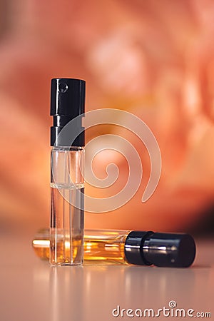 Two perfume samples with aroma water against peonies in soft focus. Face serum, essential oil Stock Photo