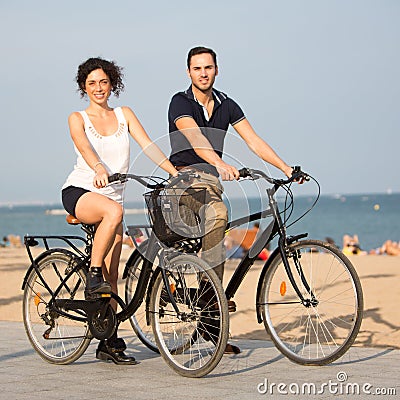 Two persons cycling on the coast Stock Photo