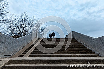 Two persons walking on the concrete bridge Stock Photo