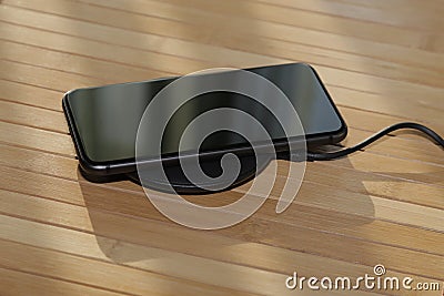 Two phones on charging one wired another wireles Stock Photo