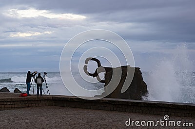 Two photographers in El Peine de los Vientos in the city of San Sebastian Editorial Stock Photo