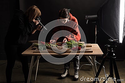 Two photographers making food composition for commercial photography and taking photo on digital camera Stock Photo
