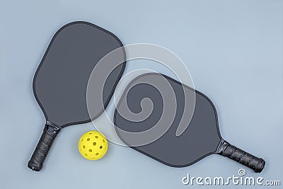 Two pickleball paddles and ball on light gray Stock Photo