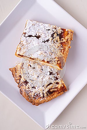 Two pieces of homemade cookies apricot jam powdered sugar in white square plate Stock Photo