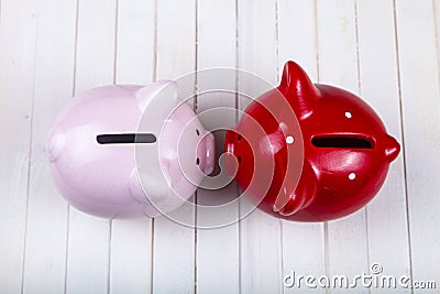 Two pigs piggy banks on a white wooden background Stock Photo