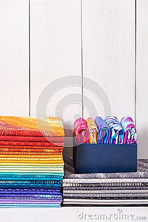 Two pile of pieces colorful quilting fabrics on white wooden background Stock Photo