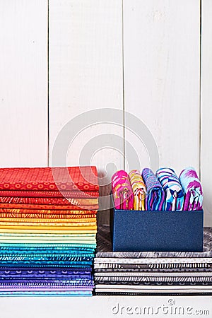 Two pile of pieces colorful quilting fabrics on white wooden background Stock Photo