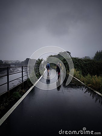 Two pilgrims walking in the rain Editorial Stock Photo