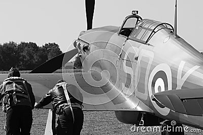 Two pilots pushing second world war hurricane fighter  plane