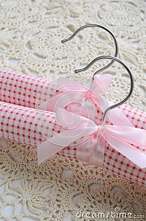 Two pink clothing hangers on crocheted background Stock Photo