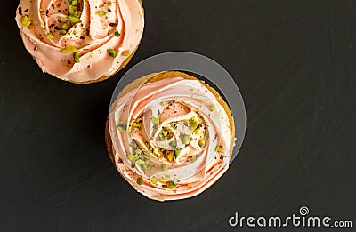 Two pink cup cakes close up on black background - Top view photo Stock Photo