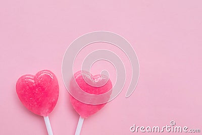 Two Pink Valentine`s day heart shape lollipop candy on empty pastel pink paper background. Love Concept. top view. Stock Photo