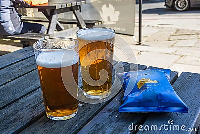 Two pints of beer and a packet of crisps Editorial Stock Photo