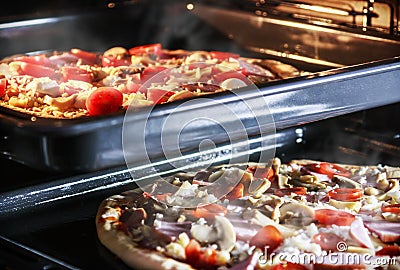 Two pizzas with mushrooms, ham and mozzarella cooked baking Stock Photo