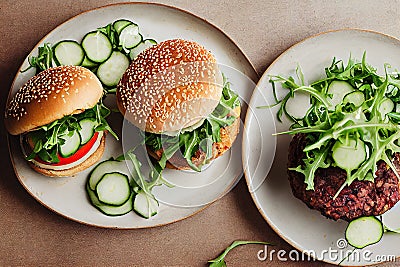 two plates with sandwiches and cucumbers on them on a table top with a knife and fork next to it Stock Photo