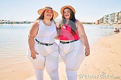 Two plus size overweight sisters twins women happy at the beach on summer holidays Stock Photo