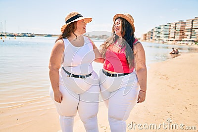 Two plus size overweight sisters twins women happy at the beach on summer holidays Stock Photo