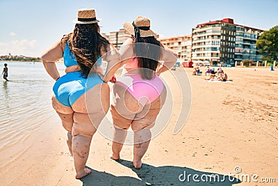 Two plus size overweight women showing legs vascular disease of varicose and thrombosis at the beach Stock Photo