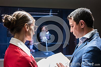 Two police detectives analyzing the files of a criminal case Stock Photo