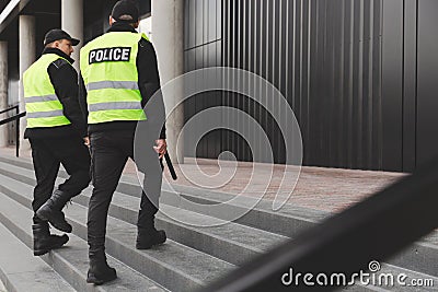 Two police officers in reflective vests patrol the streets of the city Stock Photo