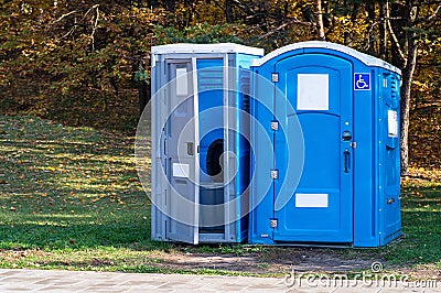 Two portable toilets in a park Stock Photo