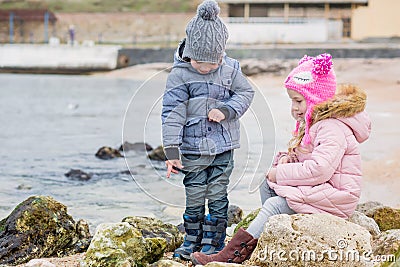 Two preschoolers actively playing on stony beach Stock Photo