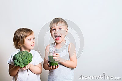 Two pretty fun kids with green smoothies and broccoli. Helthy an Stock Photo