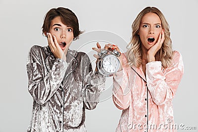 Two pretty shocked girls wearing pajamas Stock Photo