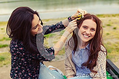 Two pretty sisters girls having fun together, field flowers in hair Stock Photo