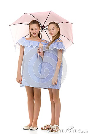 Two Pretty Sisters in Identical Light Dresses Standing Under Umb Stock Photo
