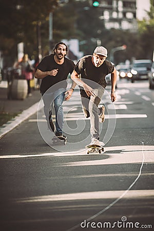 Two pro skateboard rider ride skate through cars on street Stock Photo