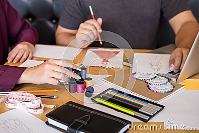 Two professional stylish fashion designer working as fashion designers measure as sketches in workshop of new collection in Stock Photo