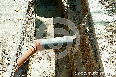 Two pvc sewer pipe connected underground in the trench on the street. Stock Photo