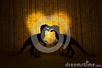 Two raptors - dinosaurs - in front of a glowing heart. Stock Photo