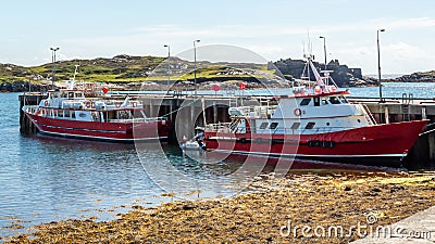 Two red boats moored in the harbor on Inishbofin Island Stock Photo