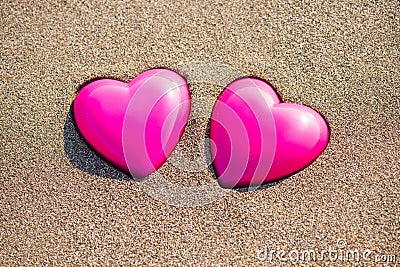 Two red hearts on the beach symbolizing love Stock Photo