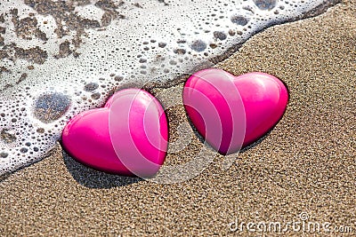 Two red hearts on the beach symbolizing love Stock Photo
