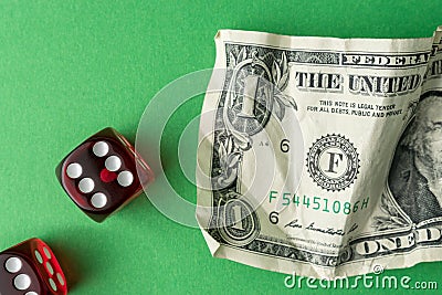 Two red playing dices with one dollar bill on green table. Luck and fortune concept Stock Photo