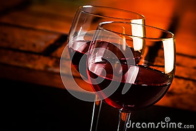 Two red wine glasses on wood table with warm atmosphere background Stock Photo