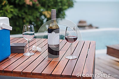 Two Red wines glasses near swimming pool. Summer travel, vacation, holiday and happy weekend concept Stock Photo