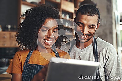 Smiling cafe owner in apron looking at digital tablet Stock Photo