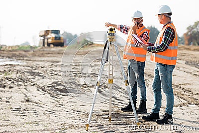 Road construction workers using measuring device on the field Stock Photo