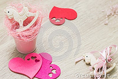 2 rocking ponies toys in pink small bucket and felt hearts flat lay. Top view. Copyspace Stock Photo