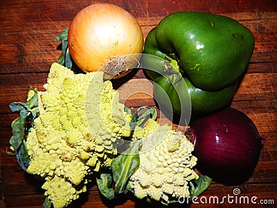 Two Romanescu cabbage, yellow onion, purple onion, green bell pepper Stock Photo