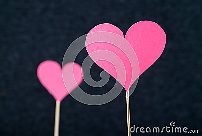 Two romantic hearts cut from cardboard or paper on wooden stick Stock Photo