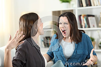 Two roommates arguing and shouting at home Stock Photo