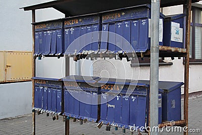 Two rows of cluster mailboxes with numbered compartments and locks on the sidewalk Stock Photo