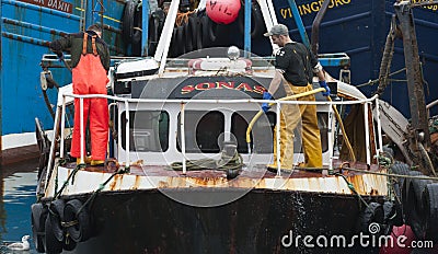 Two sailors working and cleaning on the deck of a fishing boat. Editorial Stock Photo