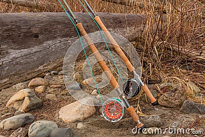 Two salmon spey fly rods resting on a log in the late afternoon sun Stock Photo